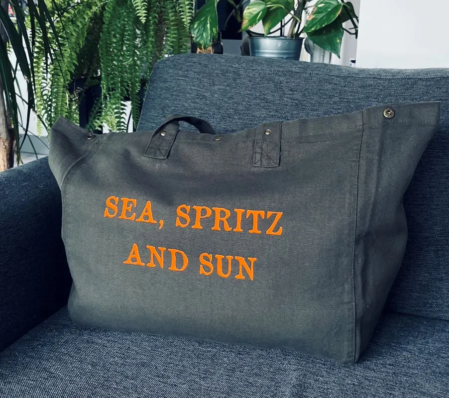 Sac fourre-tout kaki avec flocage "Sea, Spritz and Sun" en orange fluo.