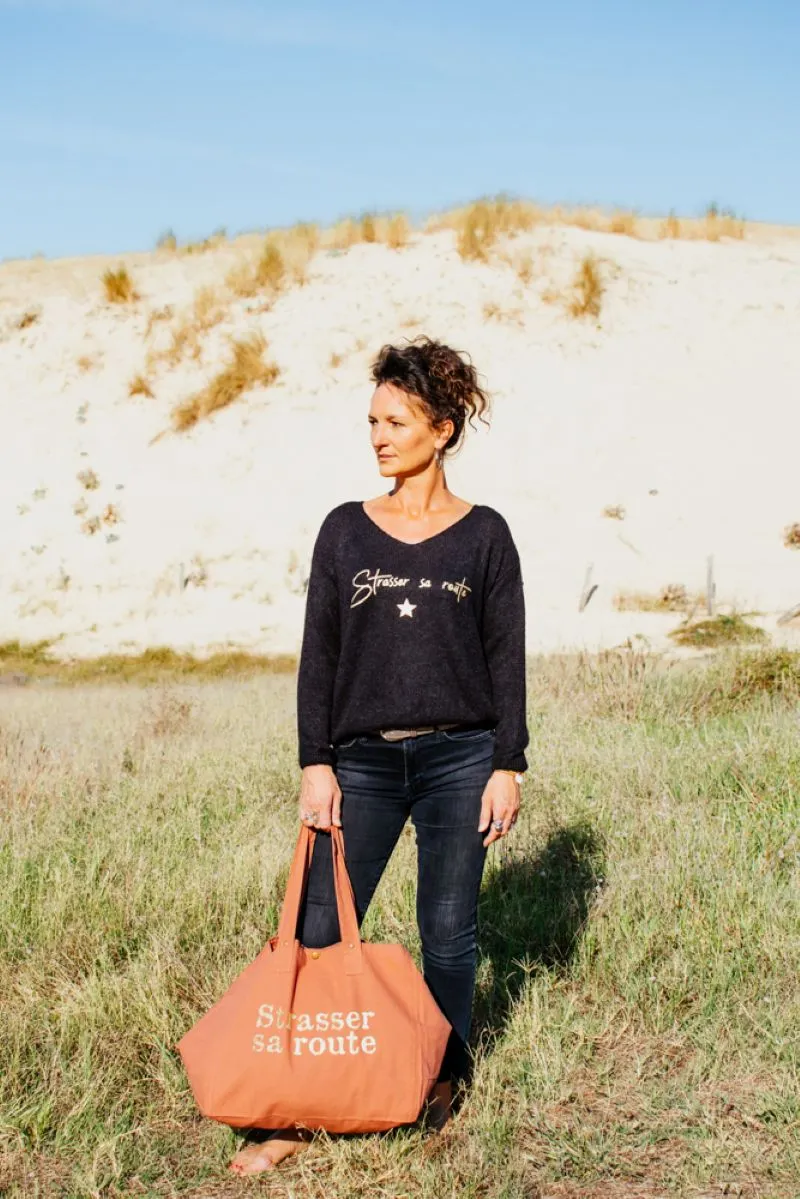 Pull noir en alpaga pour femme, col V avec flocage "Strasser sa route " en or pailleté.