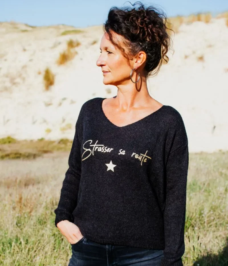 Pull noir en alpaga pour femme, col V avec flocage "Strasser sa route " en or pailleté.