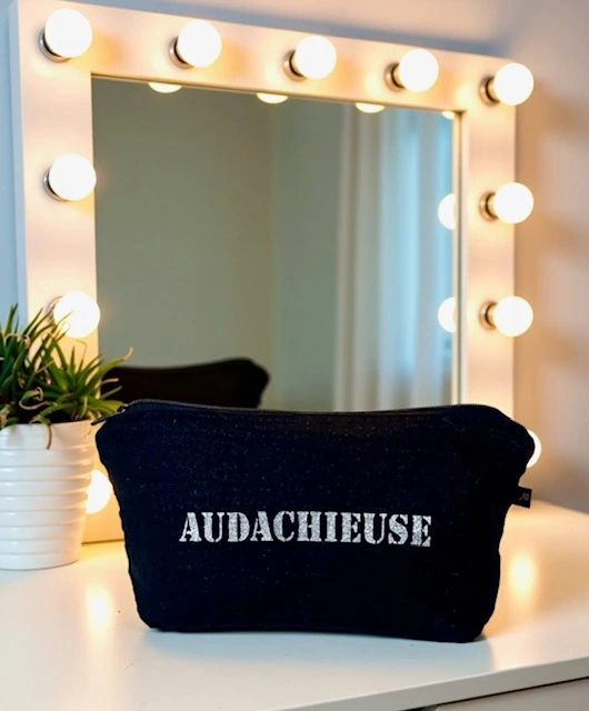 Petite pochette en gaze de coton noir scintillant avec son inscription "Audachieuse" en argent pailleté. Fait main en série limitée.