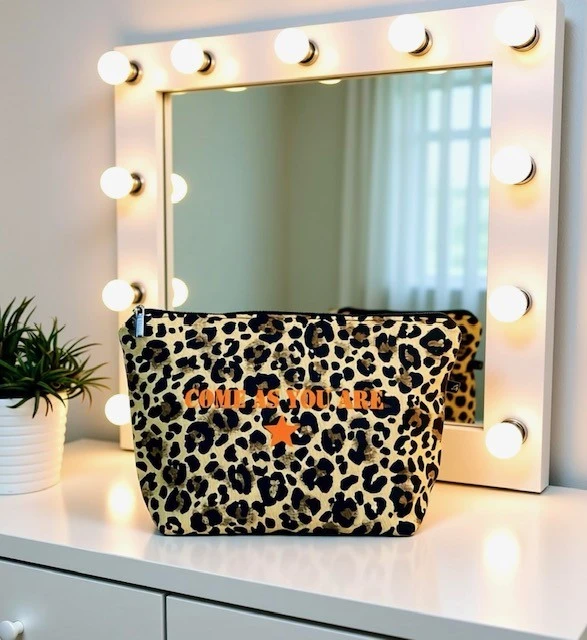 Trousse de toilette en denim léopard avec son inscription "Come as you are" en orange fluo. Fait main en série limitée. Création signée La Strasseuse