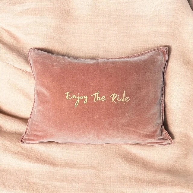 Housse de coussin rectangulaire en velours de coton vieux rose avec flocage "Enjoy the ride" en doré mat.