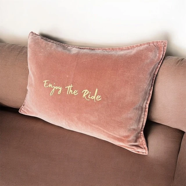 Housse de coussin rectangulaire en velours de coton vieux rose avec flocage "Enjoy the ride" en doré mat.
