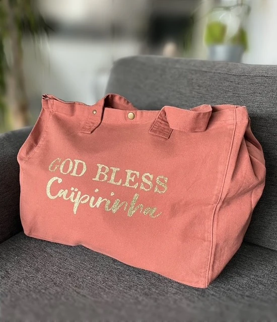 Sac fourre-tout vieux rose avec "God bless Caïpirinha" en or pailleté.
