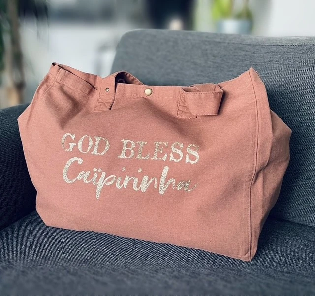 Sac fourre-tout santal avec "God bless Caïpirinha" en or pailleté.