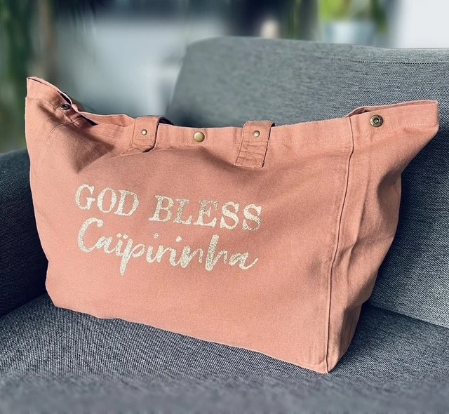 Sac fourre-tout santal avec "God bless Caïpirinha" en or pailleté.
