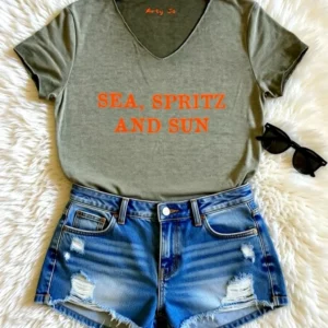Tee-shirt kaki col V avec son slogan "Sea, Spritz and Sun" en orange fluo.