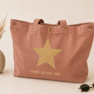 Sac cabas santal « Come As You Are » avec grande étoile orange fluo, présenté sur un fond clair et élégant avec un vase en céramique et des lunettes de soleil.