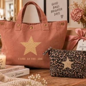 Duo cadeau La Strasseuse : sac cabas XXL santal « Come As You Are » à étoile or pailletée et trousse de toilette léopard à étoile champagne, à côté d'un paquet cadeau.