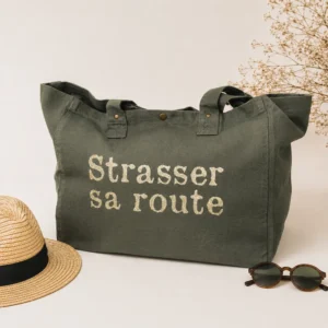 Sac fourre-tout kaki - Slogan "Strasser sa route" en doré pailleté, sur fond clair avec chapeau de paille et lunettes de soleil. Création La Strasseuse.